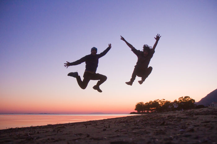 Jumping in the air at sunset sun Greece