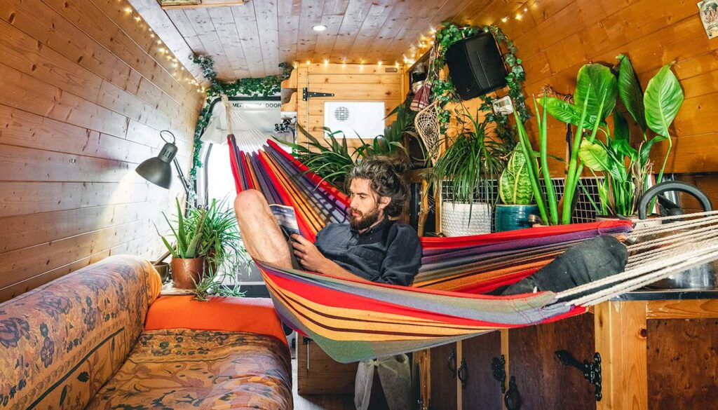 reading a book sat in hammock in my campervan