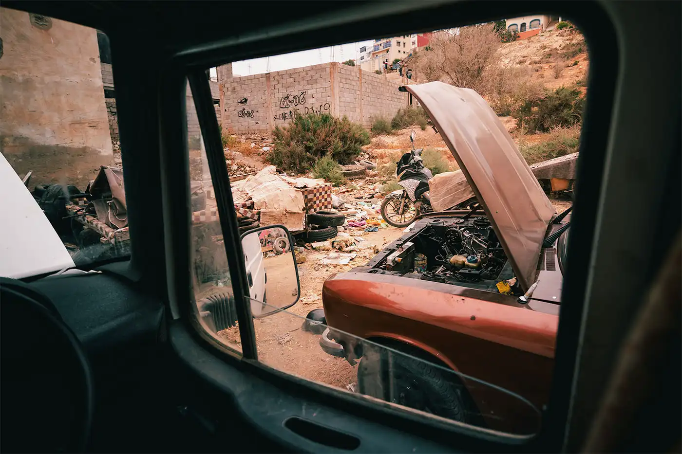 view of scrapyard mechanics garage from inside passenger window 